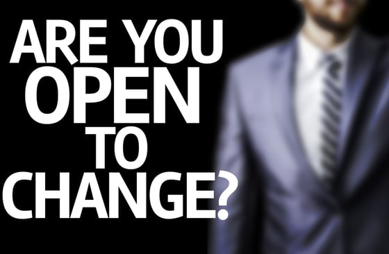 Are you Open to Change? written on a board with a business man on background